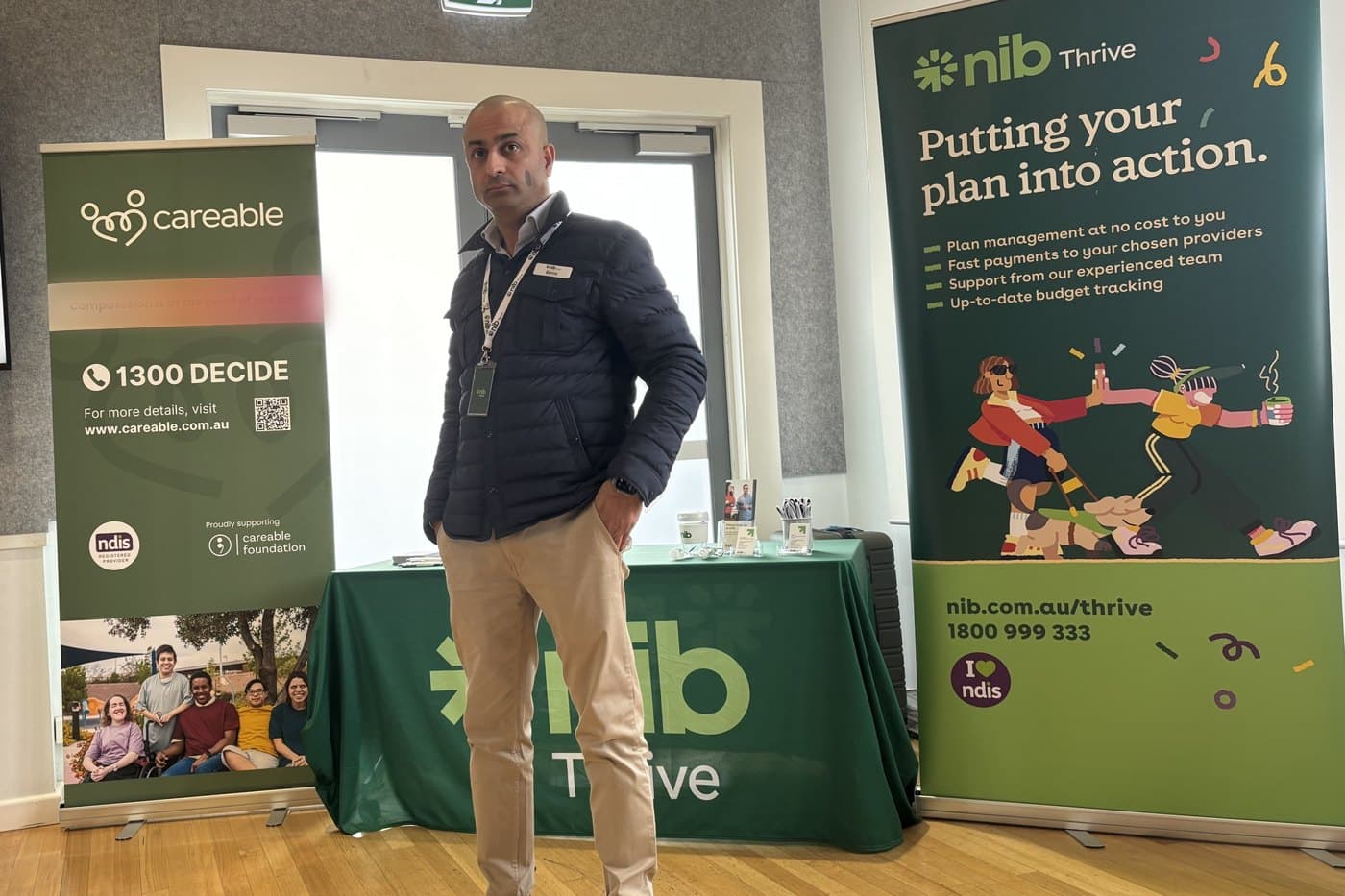 Benny Malhotra of nib Thrive standing between the Careable and nib Thrive banners