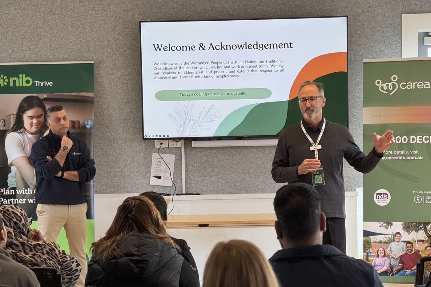 Simon Dix of nib Thrive presenting, with Vivek standing beside the nib banner
