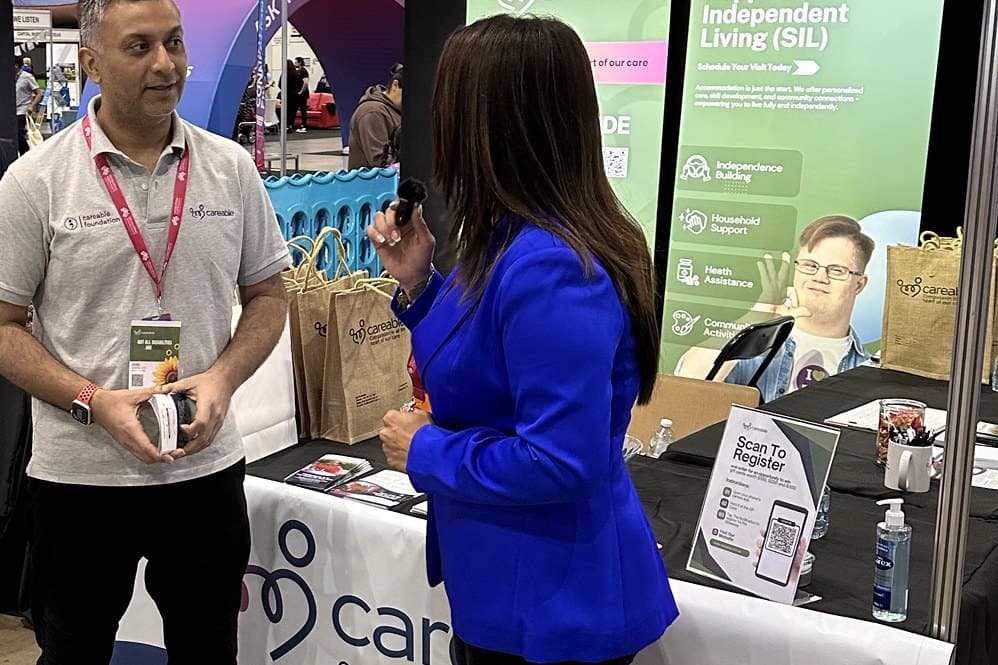 Vivek talking with a visitor at the Careable stand